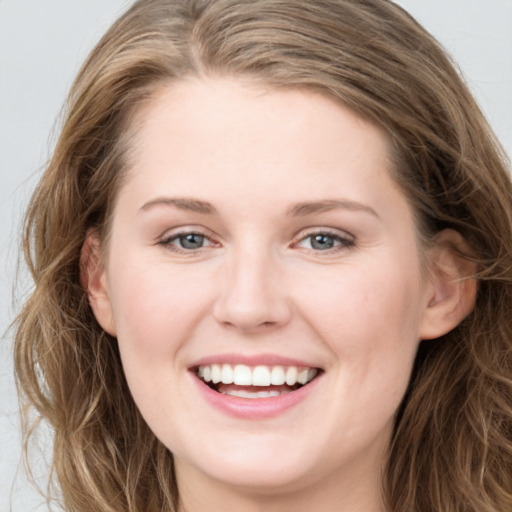 Joyful white young-adult female with long  brown hair and grey eyes