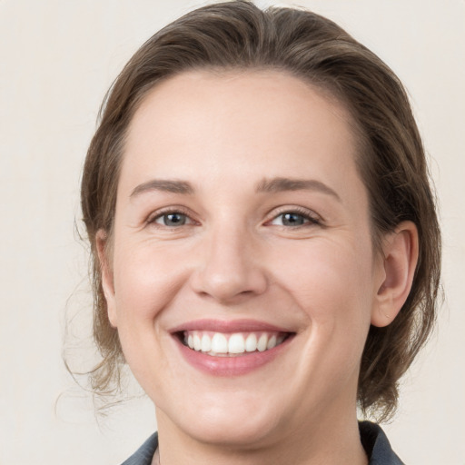 Joyful white young-adult female with medium  brown hair and grey eyes