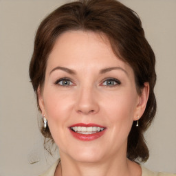 Joyful white adult female with medium  brown hair and grey eyes