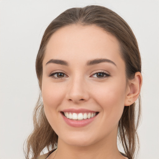 Joyful white young-adult female with long  brown hair and grey eyes