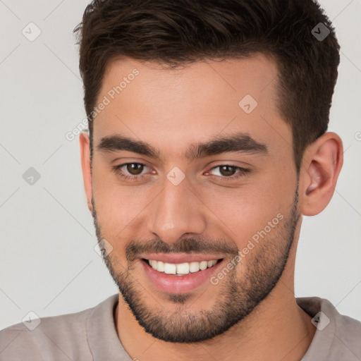 Joyful white young-adult male with short  brown hair and brown eyes