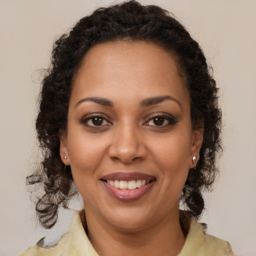 Joyful black young-adult female with medium  brown hair and brown eyes