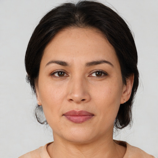 Joyful latino adult female with medium  brown hair and brown eyes