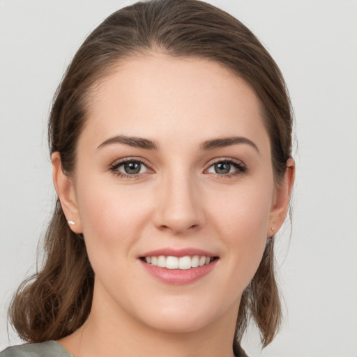 Joyful white young-adult female with medium  brown hair and grey eyes