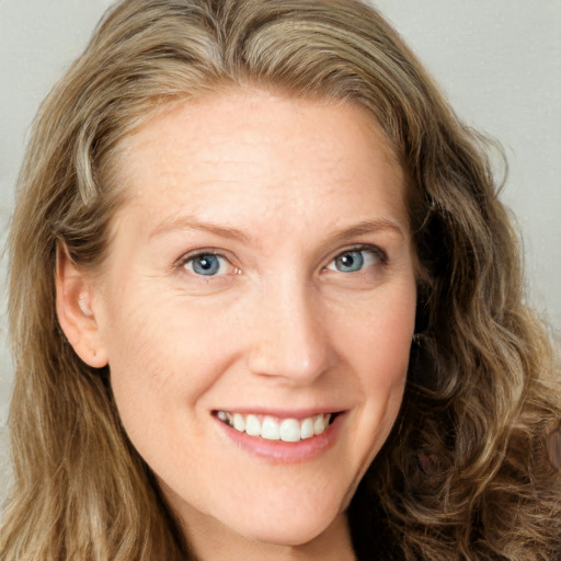 Joyful white adult female with long  brown hair and green eyes