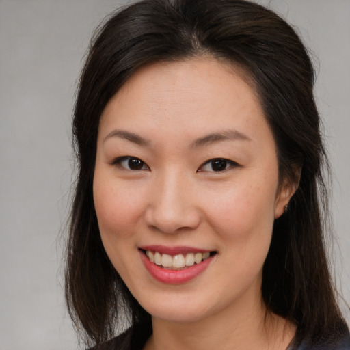 Joyful asian young-adult female with long  brown hair and brown eyes