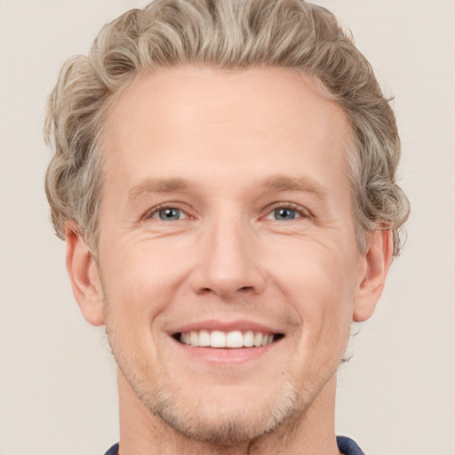 Joyful white adult male with short  brown hair and grey eyes