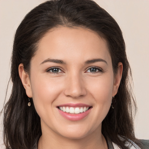 Joyful white young-adult female with long  brown hair and brown eyes