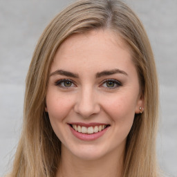 Joyful white young-adult female with long  brown hair and green eyes