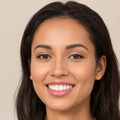 Joyful latino young-adult female with long  brown hair and brown eyes