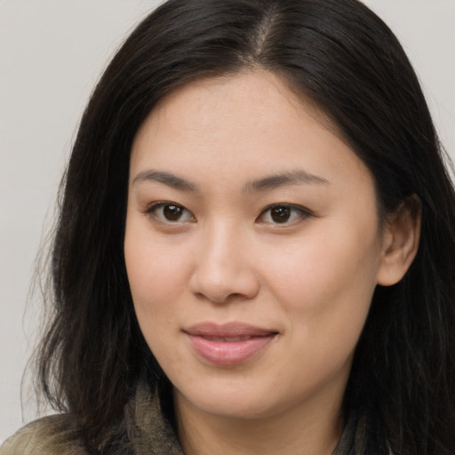 Joyful asian young-adult female with long  brown hair and brown eyes