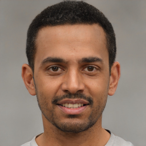 Joyful latino young-adult male with short  black hair and brown eyes