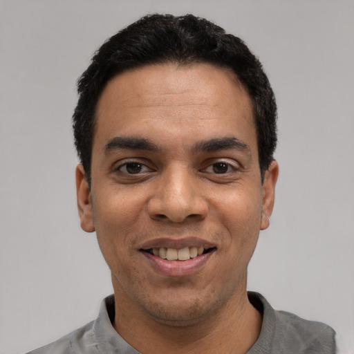 Joyful white young-adult male with short  black hair and brown eyes