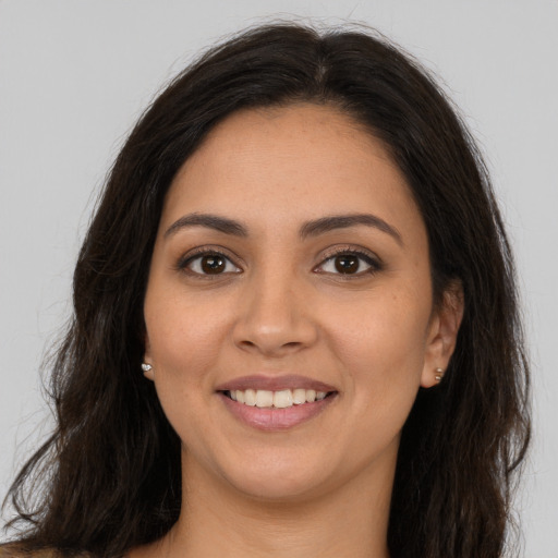 Joyful latino young-adult female with long  brown hair and brown eyes