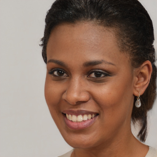 Joyful black young-adult female with medium  brown hair and brown eyes