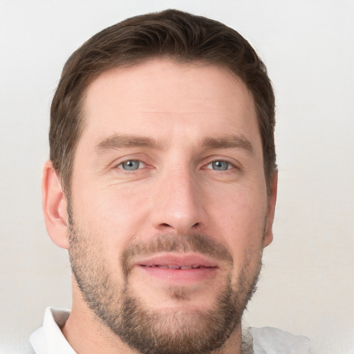 Joyful white young-adult male with short  brown hair and grey eyes