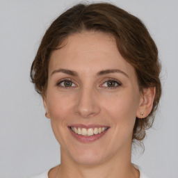 Joyful white young-adult female with medium  brown hair and green eyes