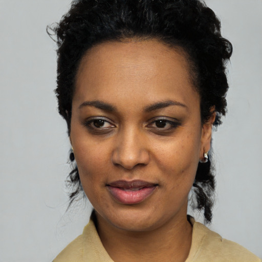 Joyful black young-adult female with short  black hair and brown eyes