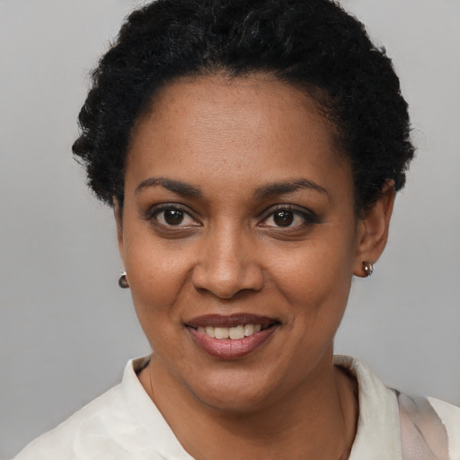 Joyful black young-adult female with short  black hair and brown eyes