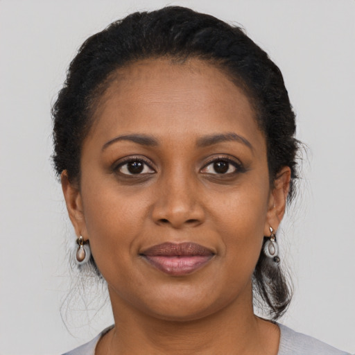 Joyful black young-adult female with medium  brown hair and brown eyes