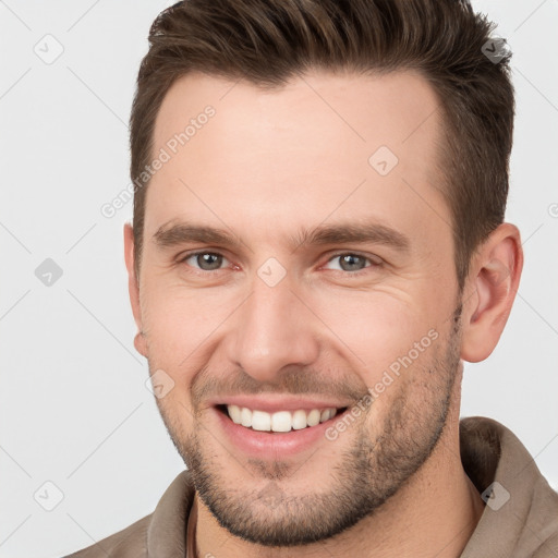 Joyful white young-adult male with short  brown hair and brown eyes