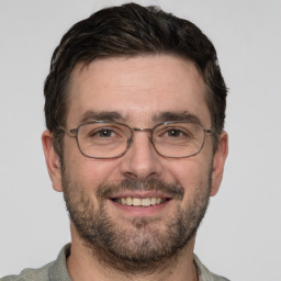 Joyful white adult male with short  brown hair and grey eyes