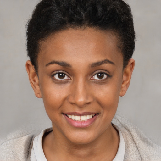 Joyful black young-adult female with short  brown hair and brown eyes