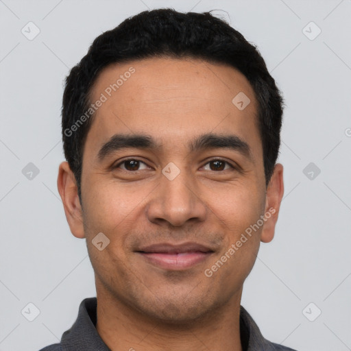 Joyful latino young-adult male with short  black hair and brown eyes