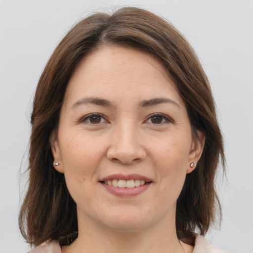 Joyful white young-adult female with medium  brown hair and brown eyes