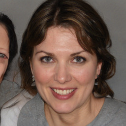 Joyful white adult female with medium  brown hair and blue eyes