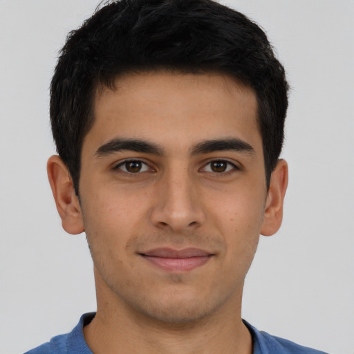 Joyful latino young-adult male with short  brown hair and brown eyes