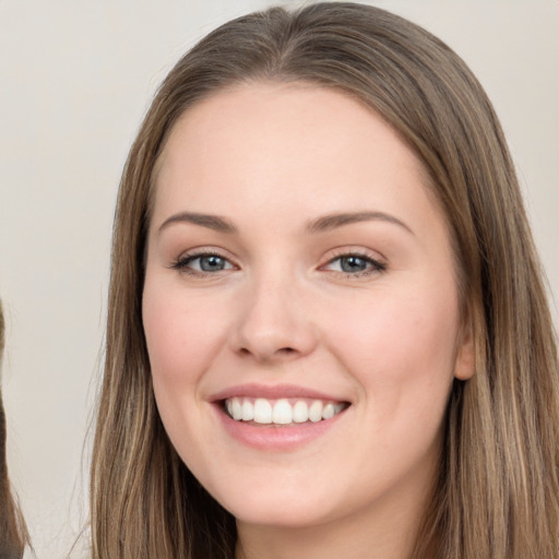 Joyful white young-adult female with long  brown hair and grey eyes