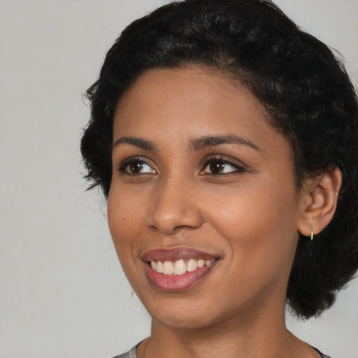 Joyful black young-adult female with medium  black hair and brown eyes