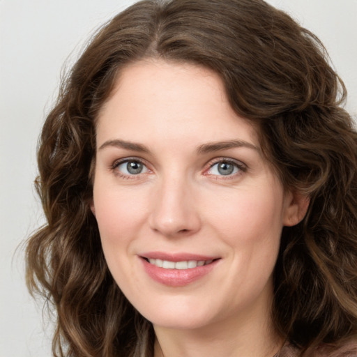 Joyful white young-adult female with long  brown hair and green eyes