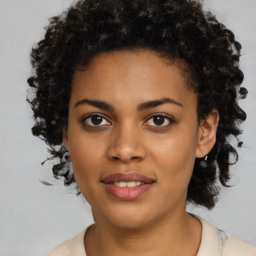 Joyful black young-adult female with medium  brown hair and brown eyes