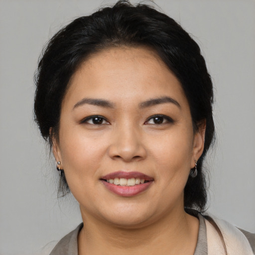 Joyful latino young-adult female with medium  brown hair and brown eyes