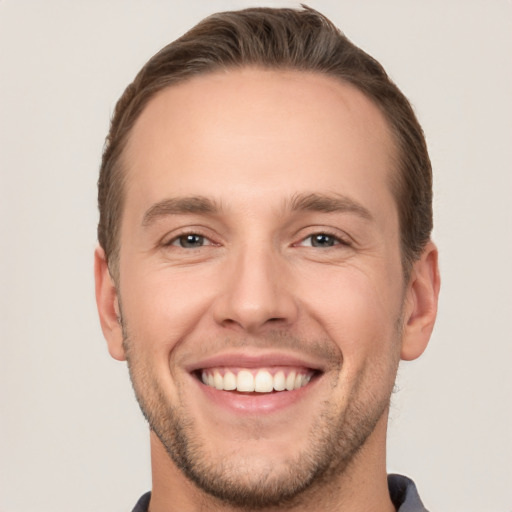 Joyful white young-adult male with short  brown hair and brown eyes