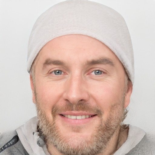 Joyful white adult male with short  brown hair and blue eyes