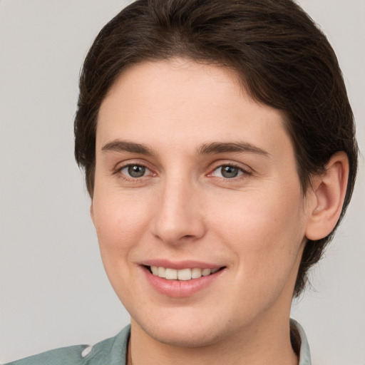 Joyful white young-adult female with short  brown hair and grey eyes