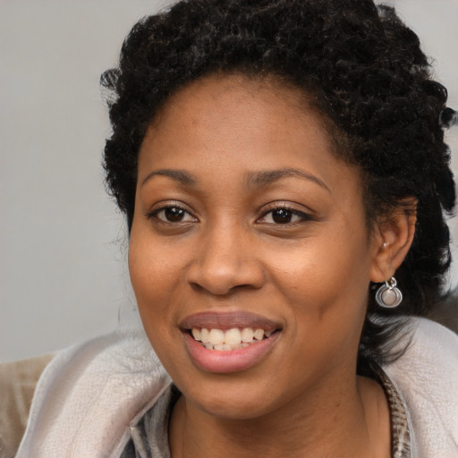 Joyful black young-adult female with long  brown hair and brown eyes