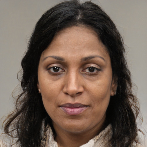 Joyful latino adult female with long  brown hair and brown eyes