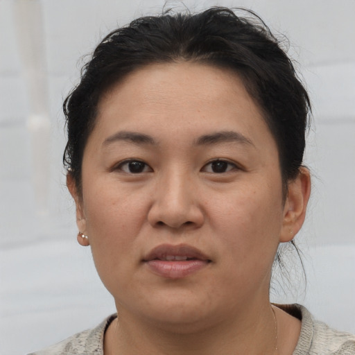 Joyful asian young-adult female with short  brown hair and brown eyes