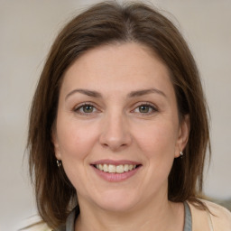 Joyful white adult female with medium  brown hair and grey eyes