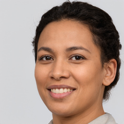 Joyful latino young-adult female with short  brown hair and brown eyes