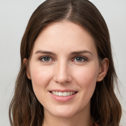 Joyful white young-adult female with long  brown hair and grey eyes