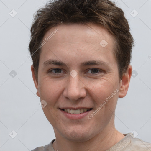 Joyful white young-adult male with short  brown hair and grey eyes