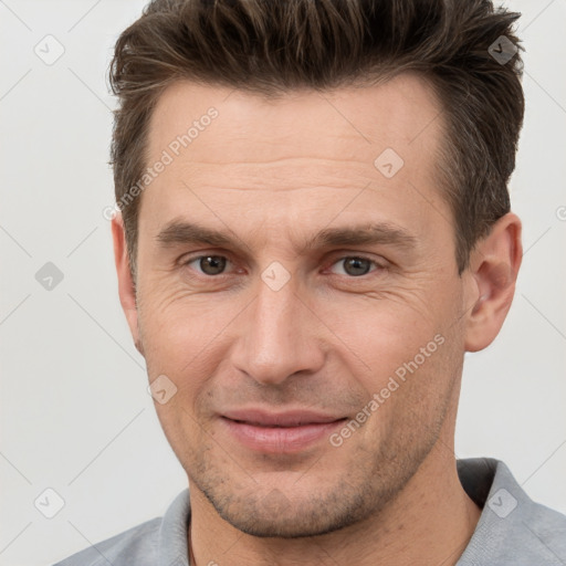 Joyful white adult male with short  brown hair and brown eyes