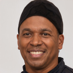 Joyful black adult male with short  black hair and brown eyes