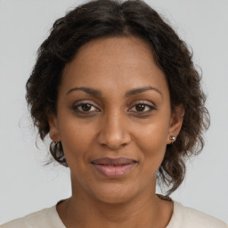 Joyful black adult female with medium  brown hair and brown eyes