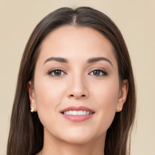 Joyful white young-adult female with long  brown hair and brown eyes